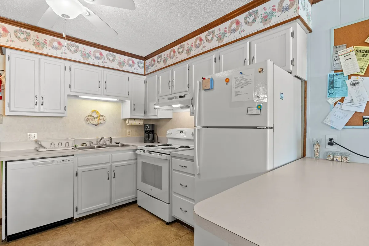 A bright kitchen view with ample counter space, dishwasher, and modern appliances. Decorative touches enhance the inviting atmosphere, suggesting a spot for both functional cooking and social interaction.
